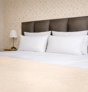 a large white bed with white pillows and a lamp at Villa Tatjana Quiet Boutique Guest House in Rogaška Slatina