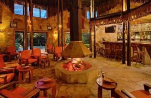a restaurant with a fireplace in the middle of a room at Sekenani,Leparan Lodge in Narok