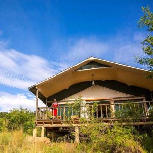 a man standing on the balcony of a house at Sekenani,Leparan Lodge in Narok