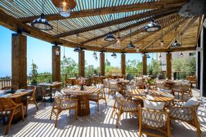 a restaurant with wooden tables and chairs on a deck at Hotel Canaan - Fattal Limited Edition in Safed