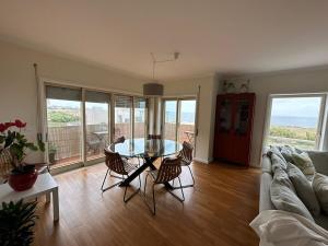 a living room with a glass table and chairs at Apartamento vista mar in Labruge