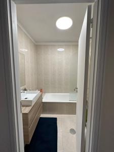a bathroom with a tub and a sink and a toilet at Apartamento vista mar in Labruge +10 photos