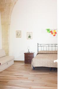 a bedroom with a bed and a wooden floor at La Campina de Don Paulu in Galatina