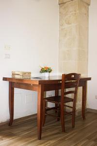 a wooden table with a chair next to a wall at La Campina de Don Paulu in Galatina +43 photos