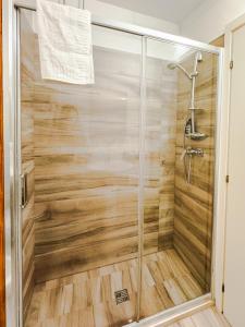 a shower in a bathroom with a wooden wall at La Campina de Don Paulu in Galatina