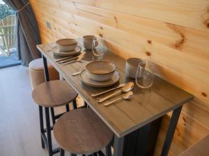 a table with plates and bowls and glasses on it at Bayview Glamping Pods Kerry in Ballyheigue