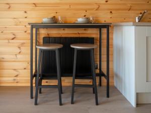 a bar with two stools under a table in a kitchen at Bayview Glamping Pods Kerry in Ballyheigue