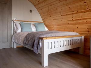 a bedroom with a bed with a wooden wall at Bayview Glamping Pods Kerry in Ballyheigue +28 photos