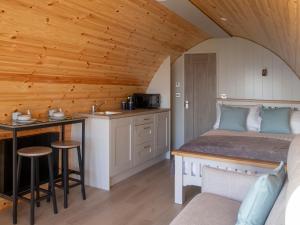 a bedroom with a bed and a kitchen at Bayview Glamping Pods Kerry in Ballyheigue