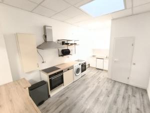 a kitchen with white walls and wooden floors at 1 bedroom apartment 2 guests in Aschaffenburg