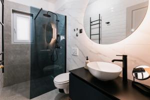 a bathroom with a sink and a toilet and a mirror at Calidum Boutique Suites in Šibenik
