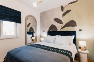 a bedroom with a bed with a painting on the wall at Calidum Boutique Suites in Šibenik