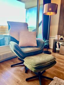 a chair with a pillow and a lamp in a room at Premium Apartment-OstseePur-inklusive Parkplatz-Wlan-Strand-und Citynähe in Timmendorfer Strand