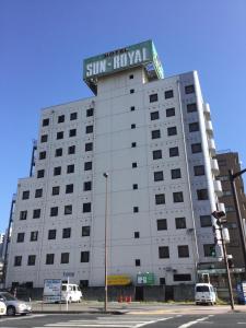 a white building with a sign on top of it at Hotel Sun Royal Utsunomiya in Utsunomiya