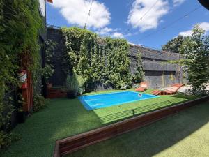 a backyard with a swimming pool and grass at Estadía con opción jacuzzi Villa Alemana in Villa Alemana