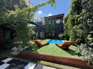 a backyard with a swimming pool and chairs and grass at Estadía con opción jacuzzi Villa Alemana in Villa Alemana
