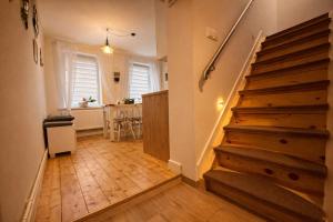 a hallway with stairs and a dining room with a table at Domek Przy Termach in Jelenia Góra +4 photos