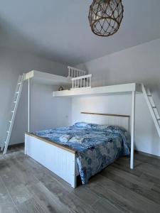 a bedroom with a white bunk bed and a staircase at Fidelica in Stintino