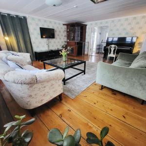a living room with two couches and a piano at Safety System Show Jumps in Enköping