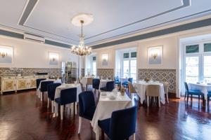 a dining room with tables and chairs and a chandelier at Casa de Sao Mamede Hotel in Lisbon