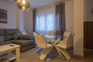a living room with a table and chairs and a couch at Piso Moredas in Dúrcal