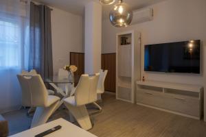 a living room with a table and a flat screen tv at Piso Moredas in Dúrcal