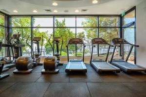 a gym with rows of treadmills in front of a large window at Hotel Canaan - Fattal Limited Edition in Safed