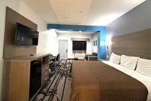 una camera d'albergo con un grande letto e una scrivania di Hotel Royale IAH Airport North Houston I-45 a Houston