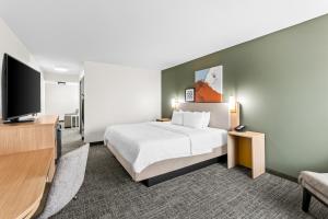 a hotel room with a bed and a flat screen tv at Spark by Hilton Bardstown in Bardstown