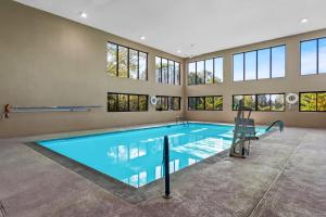 a large swimming pool in a building with windows at Spark by Hilton Bardstown in Bardstown