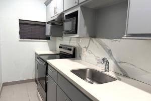 una cucina con lavello e forno a microonde di Hotel Royale IAH Airport North Houston I-45 a Houston