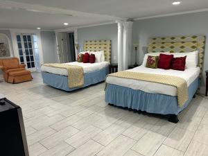a hotel room with two beds and a chair at The Inn at Cedar Grove in Vicksburg