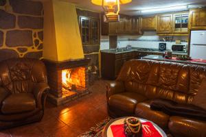 a living room with two leather couches and a fireplace at Casa da Eira in Campo do Gerês
