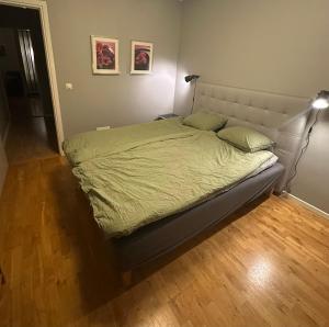 a bed in a bedroom with a wooden floor at Central accommodation in Umeå