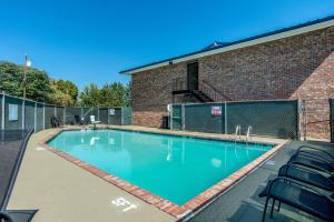 查塔努加的住宿－Motel 6-East Ridge, TN，砖砌建筑前的带椅子的游泳池