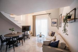 a living room with a couch and a table at ARMONIA Seaside Lofts in Maronia