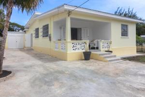 a yellow and white house with a driveway at Palasette Dover Gardens Barbados in Christ Church