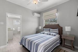 a bedroom with a bed with a blue and white striped blanket at Palasette Dover Gardens Barbados in Christ Church