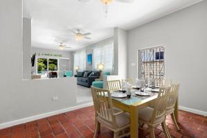 a dining room and living room with a table and chairs at Palasette Dover Gardens Barbados in Christ Church