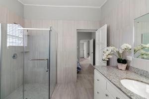 a bathroom with a glass shower and a sink at Palasette Dover Gardens Barbados in Christ Church