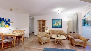 a living room with couches and a table and chairs at strandnahe FeWo mit Schwimmbad im Haus, a cappella 07, Binz in Binz