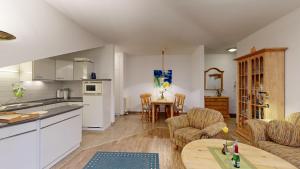 a kitchen and living room with a table and chairs at strandnahe FeWo mit Schwimmbad im Haus, a cappella 07, Binz in Binz