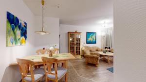 a living room with a wooden table and chairs at strandnahe FeWo mit Schwimmbad im Haus, a cappella 07, Binz in Binz