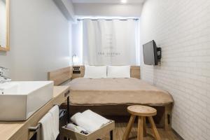 mały pokój z łóżkiem i umywalką w obiekcie Sakura Terrace The Atelier w mieście Kioto