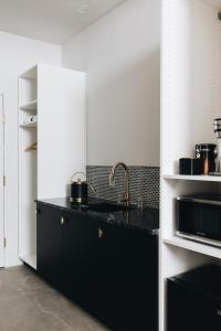 a black kitchen with a sink and a microwave at The Bellwether Hotel in Louisville
