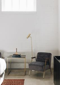 a bedroom with a table and a chair and a lamp at The Bellwether Hotel in Louisville