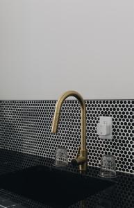a kitchen sink with a black counter top with a sink at The Bellwether Hotel in Louisville