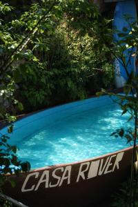 a swimming pool with blue water and trees at Casa Rover - Floripa in Florianópolis