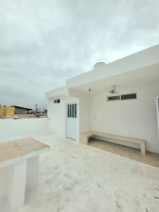 a white room with a bench on a roof at Sweethome Mérida in Mérida