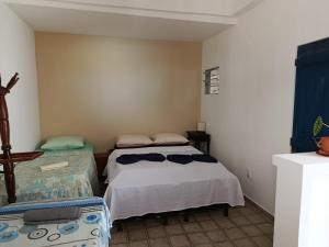 a small bedroom with a bed and a chair at Suite Quadrupla Terreo Oceazul in Conde